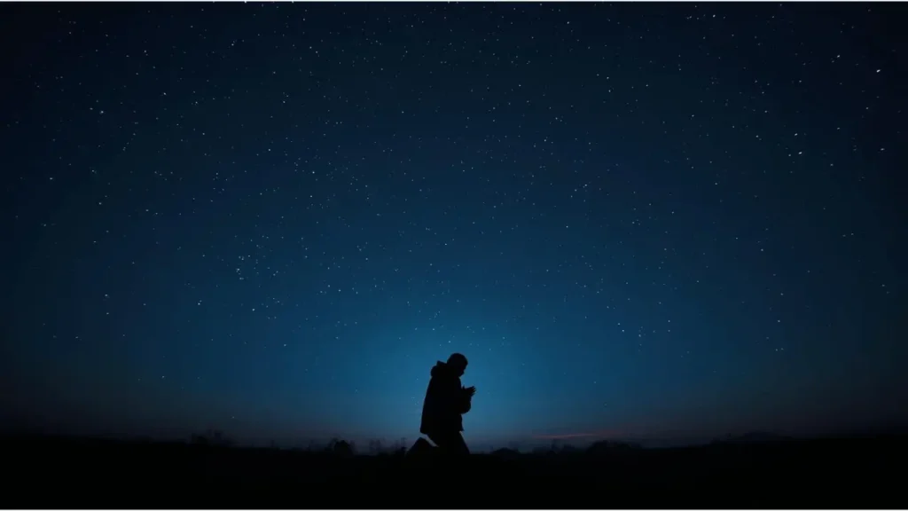Silhouette of a person praying alone at 3 a.m. under a starlit sky, symbolizing the spiritual watch hour