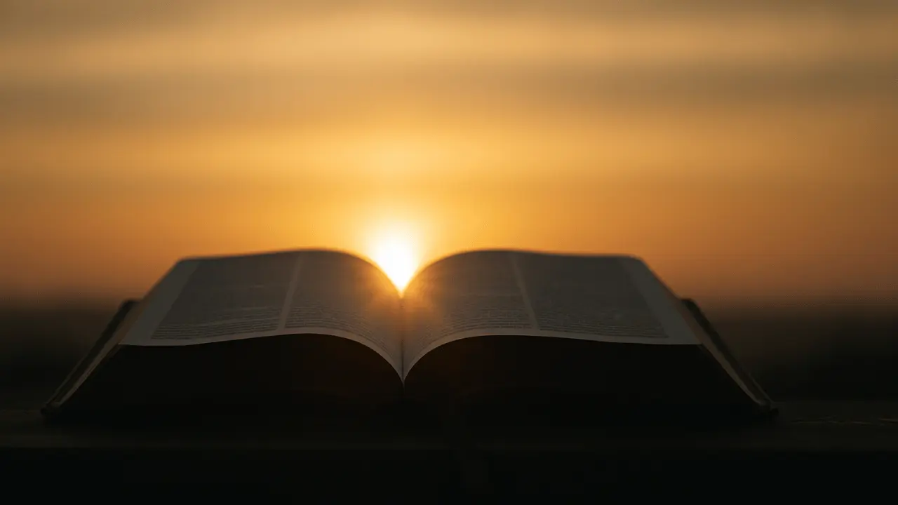 A silhouette of an open Bible glowing with soft light against a blurred background, symbolizing God’s living Word shining through generations.